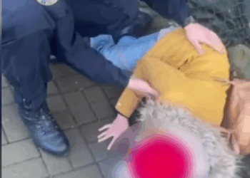 O femeie căzută pe trotuar, ajutată de jandarmi să ajungă la spital